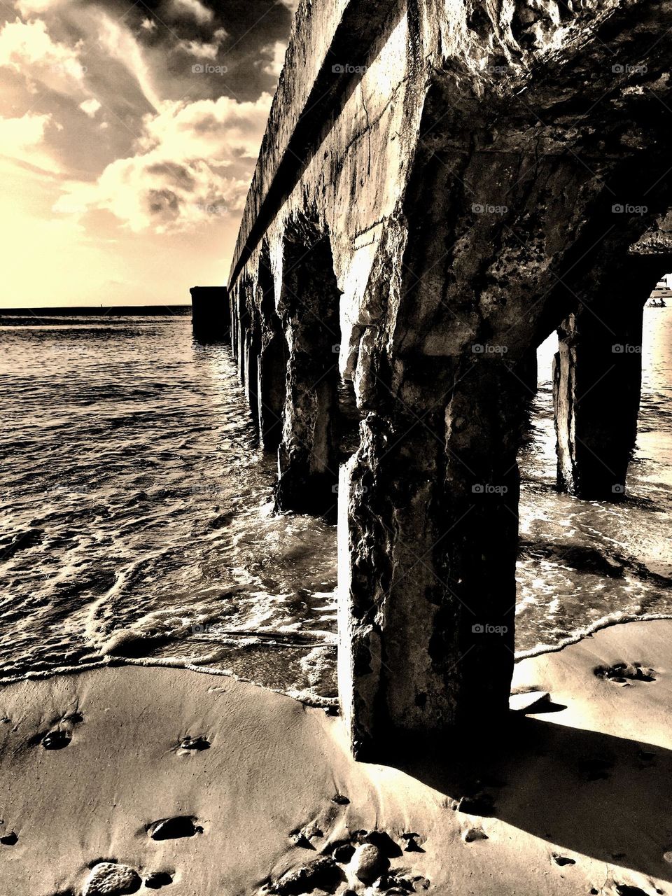 Beach scene in the Caribbean, walking along the beach, monochrome beach image, ocean in the Caribbean, under a pier, view from below a pier 