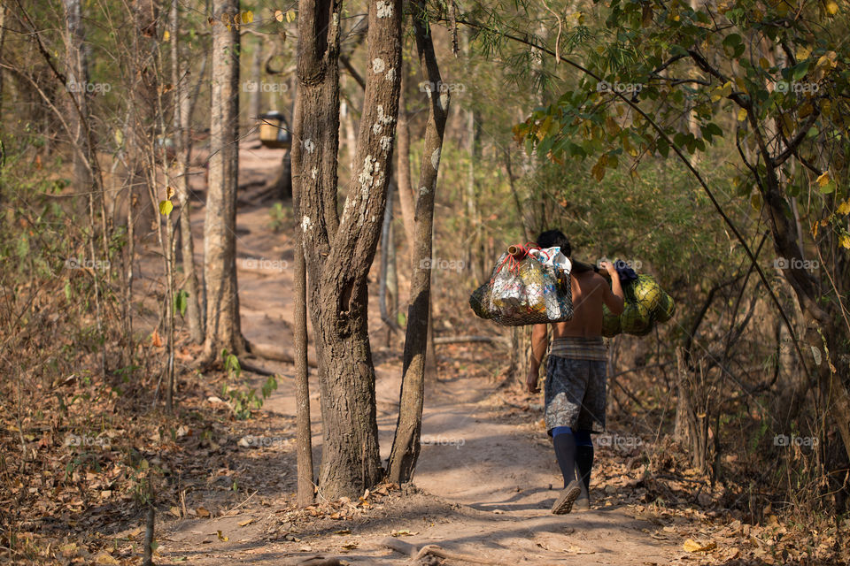 Man carrying tourist bag on the shoulder in Phu Kradueng national park 