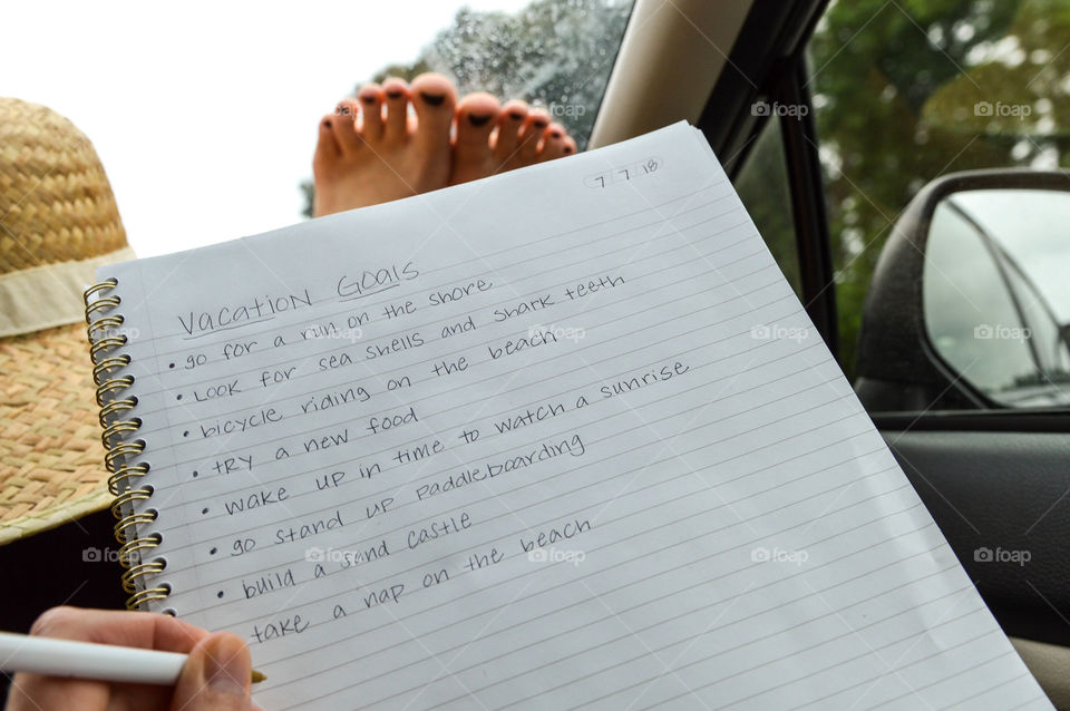 Girl writing in a notebook on a road trip