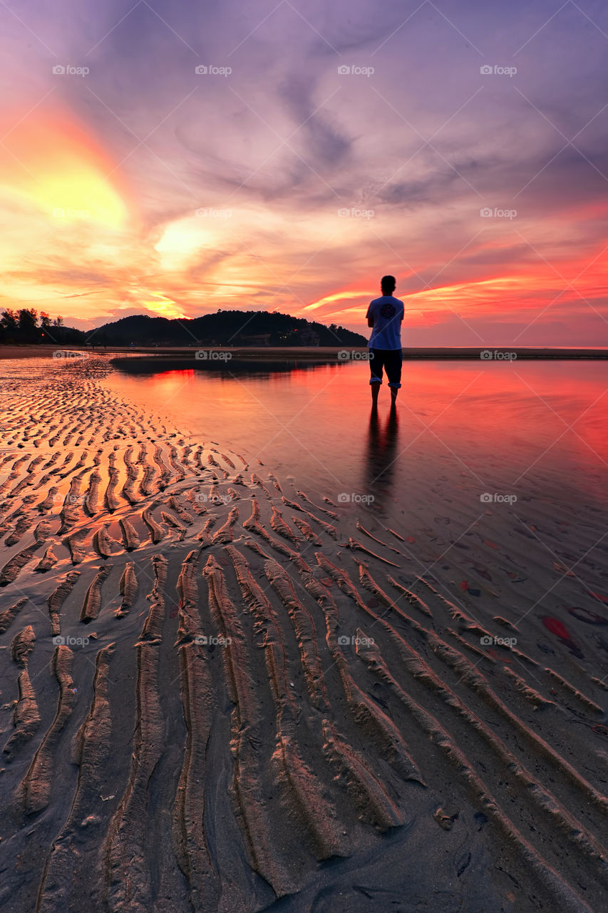 Watching sunrise. A man stand still watching sunrise at Cherating Beach Pahang