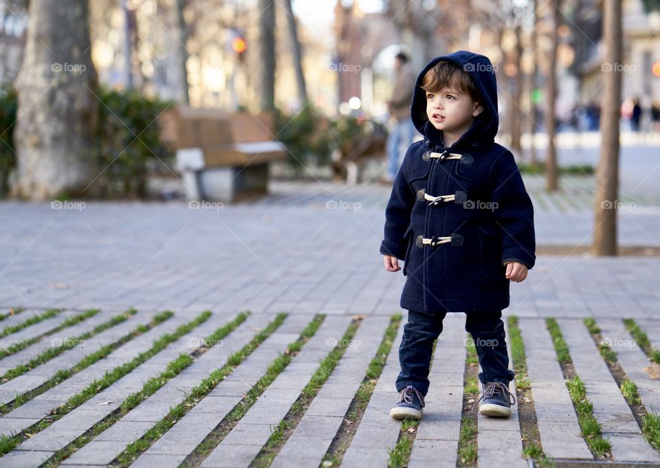 Cute boy standing on city street