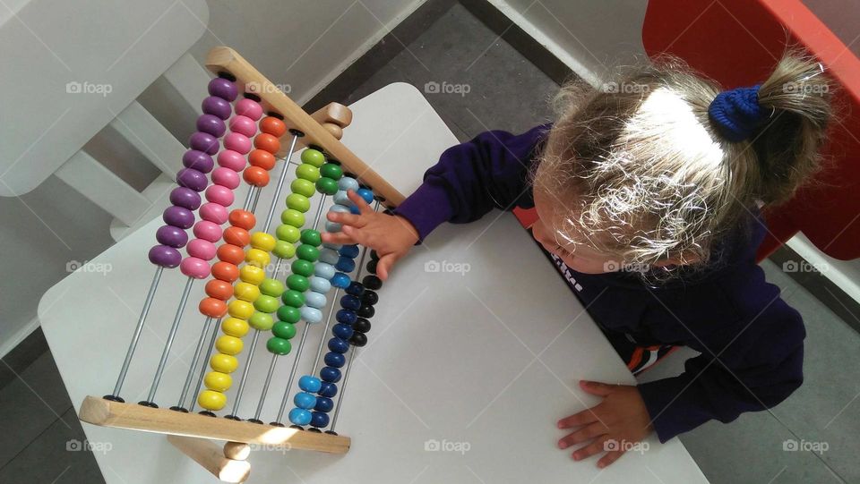 A child plays by Colored pellet setup.