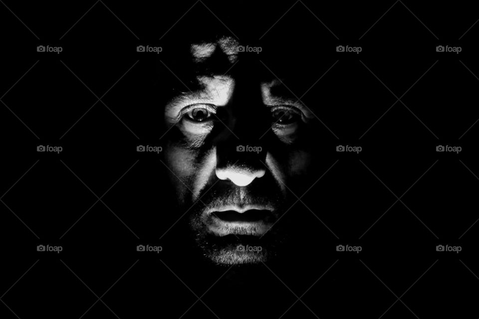 Portrait of sad man with chiaroscuro, craggy and marked face, wild man alone in the dark, dark side of human, fugitive from justice, devil and gangster