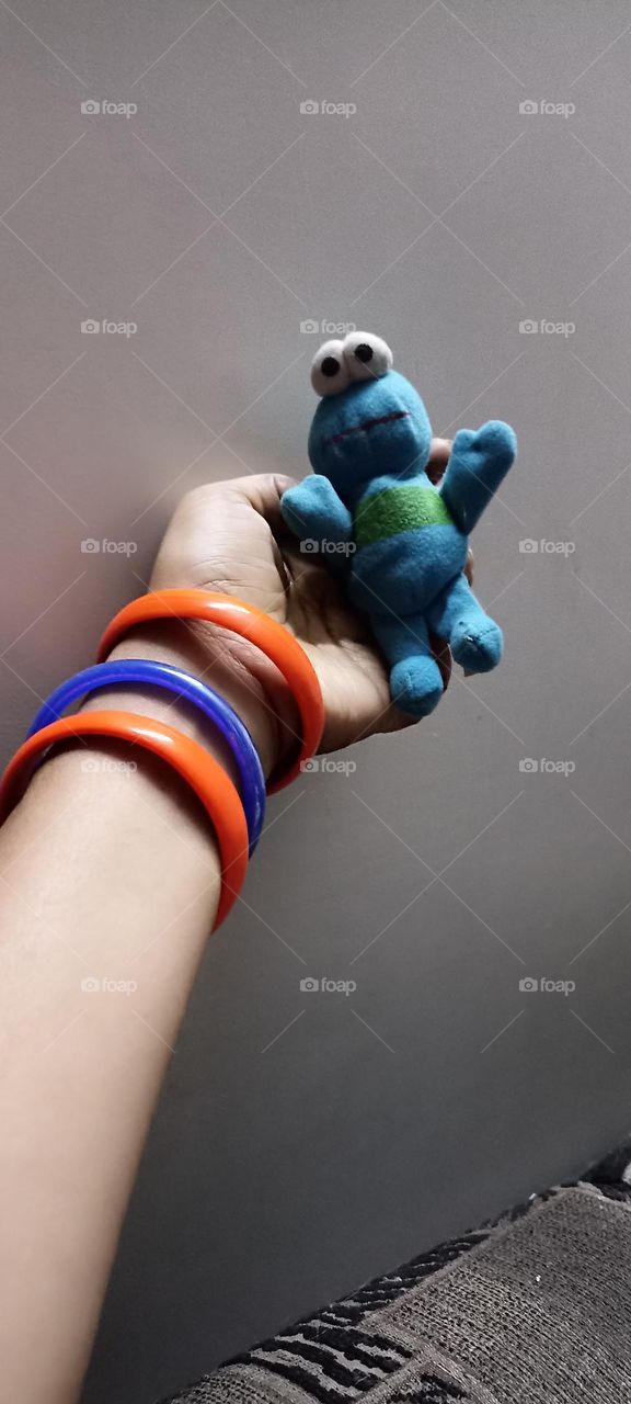 orange and blue complementary colours frog  and bangles in same hand