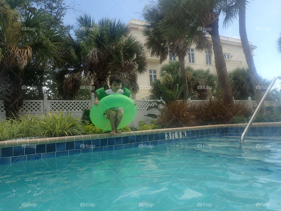 Boy in Pool. Boy jumping in.pool on a warm summer day