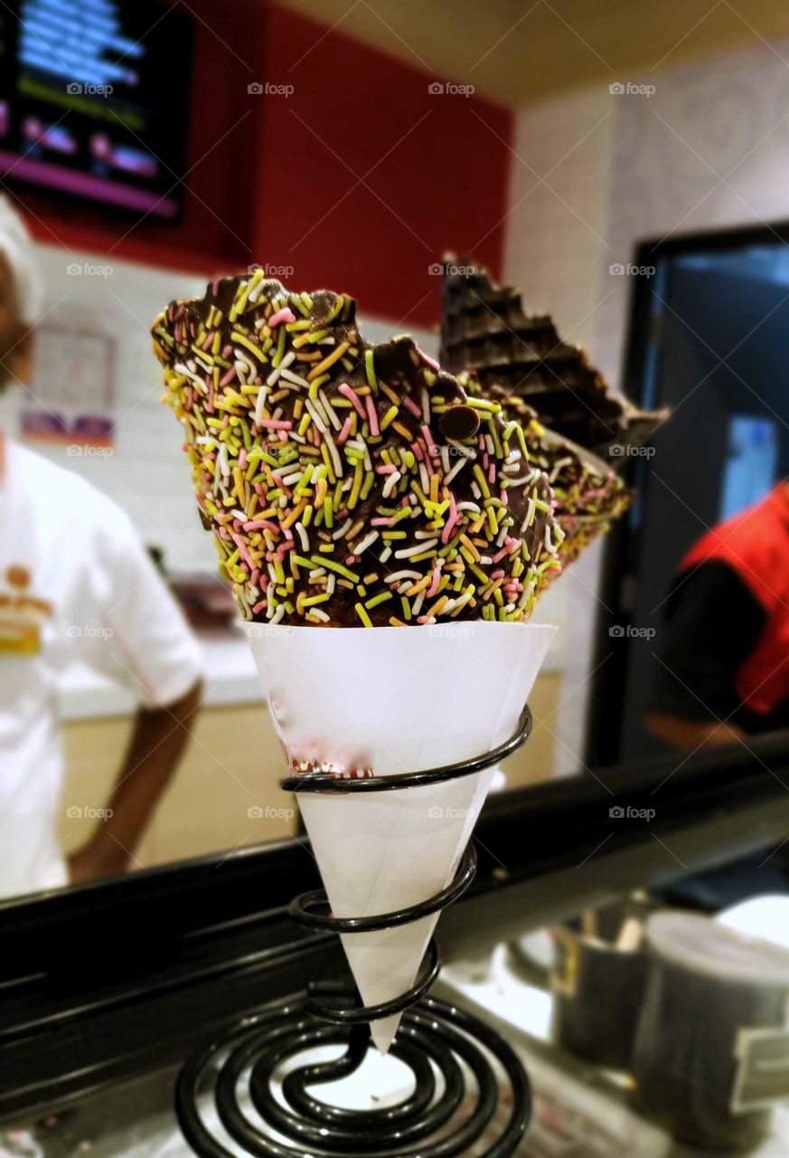 A scoop of chocolate Ice cream filled with Skittles, blueberry and strawberry. Instagram: shafiggue.k