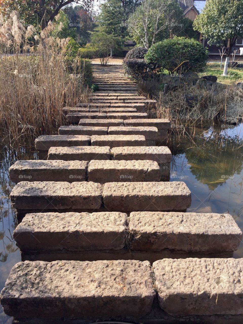 A stone plates bridge over river in a Park in Yiwu