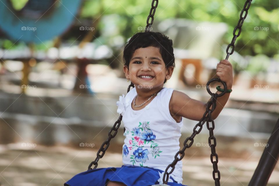 Happy girl sitting on swing