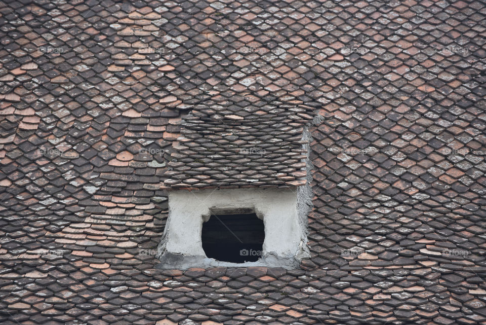 Old roof with a hole instead a window, Brasov, Romania