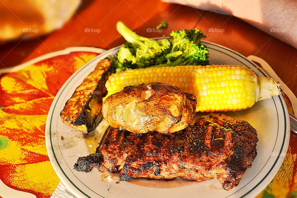 Barbecue meal. Barbecue meal on plate, corn on the cob, steak, baked potatoes, broccoli
