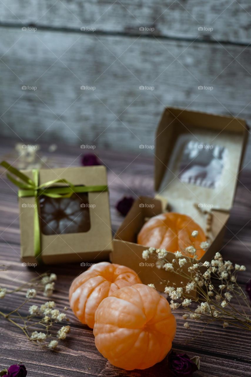 Handmade soap in the form of a tangerine on a wooden background