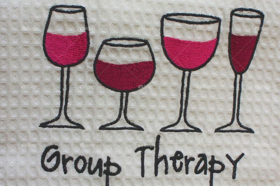 A dish towel had embroidered wine glasses and the words "Group Therapy was found in a store in a quaint town (population: 600) Micanopy, Florida.