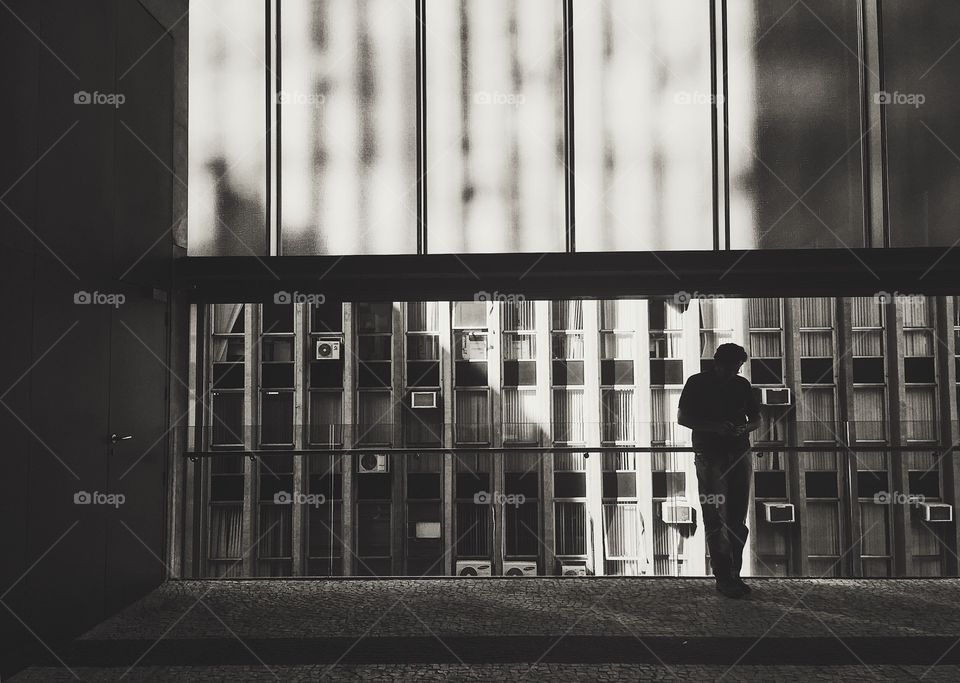 man in backlight watches the city