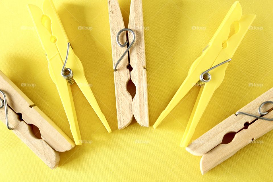 Yellow clothespin on yellow background
