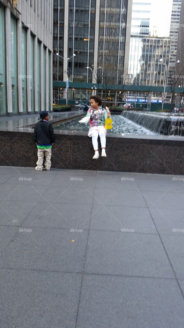 playing by fountain at Rockefeller Center