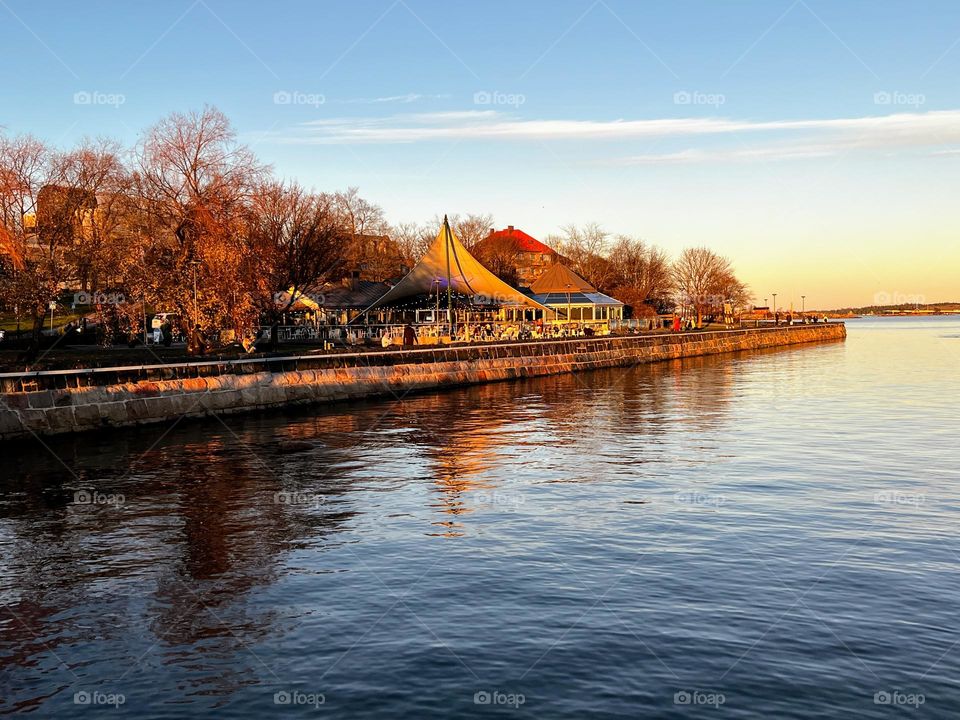 Tranquil silent landscape with low restaurant building with trees around and reflection in the Baltic Sea calm water