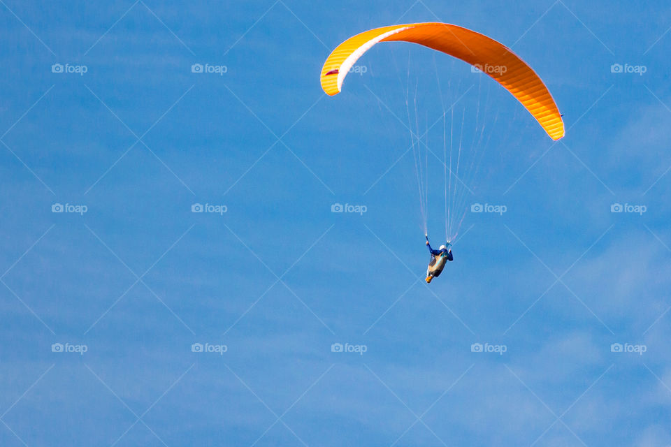 Colorful paraglider in blue sky 
