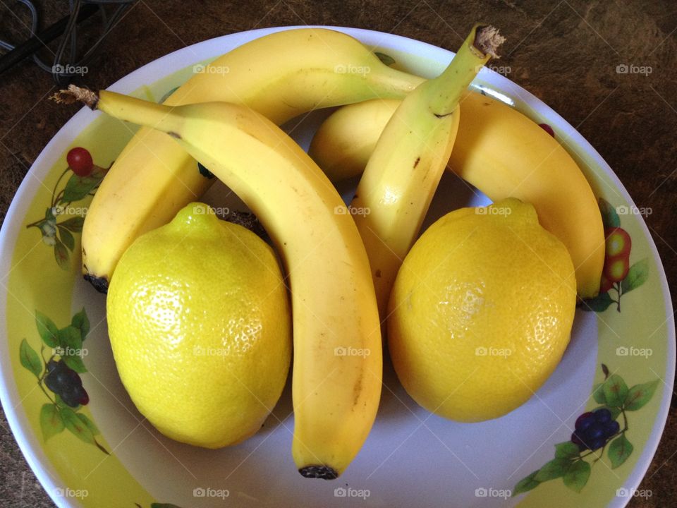 Yellow fruit. Bananas and lemons in a bowl