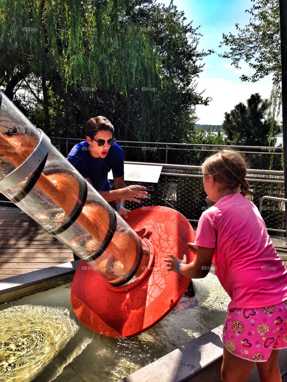 Spin it. Boy and girl spinning water in an outdoor water play exhibit