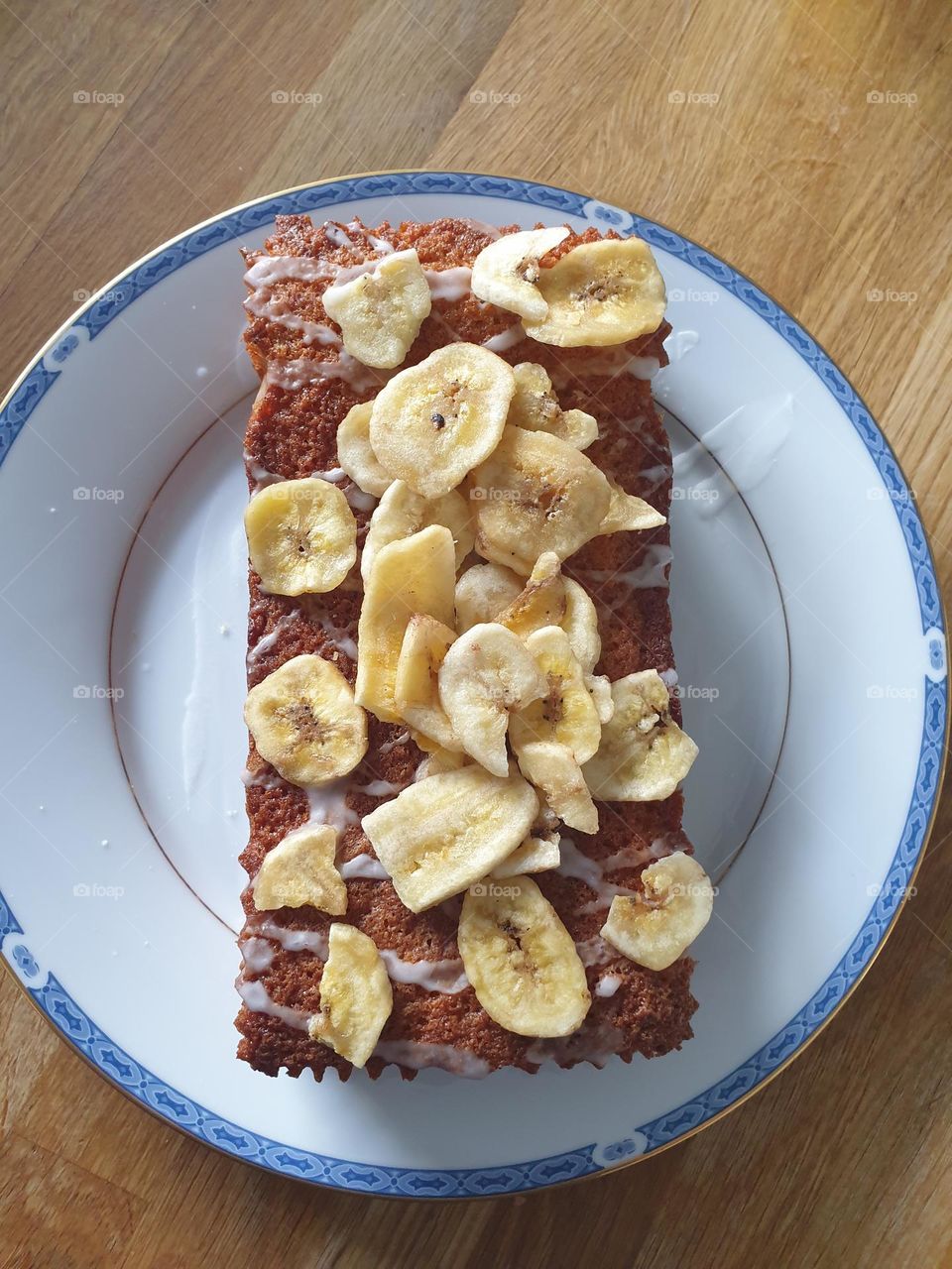 rectangular cake on circular plate, with circular/rectangular/triangular shaped banana chips