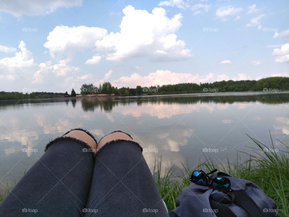 female legs resting on a lake summer landscape