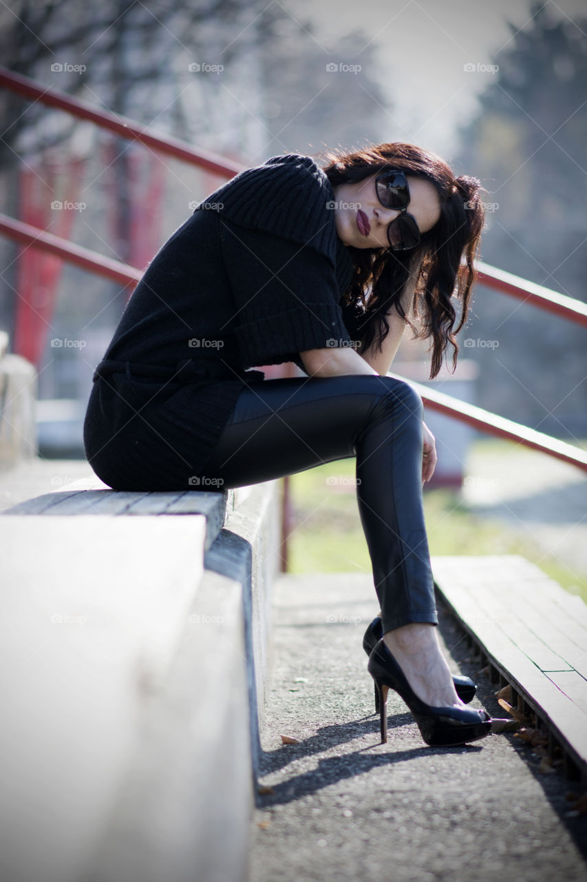 Fashionable woman sitting with high heels