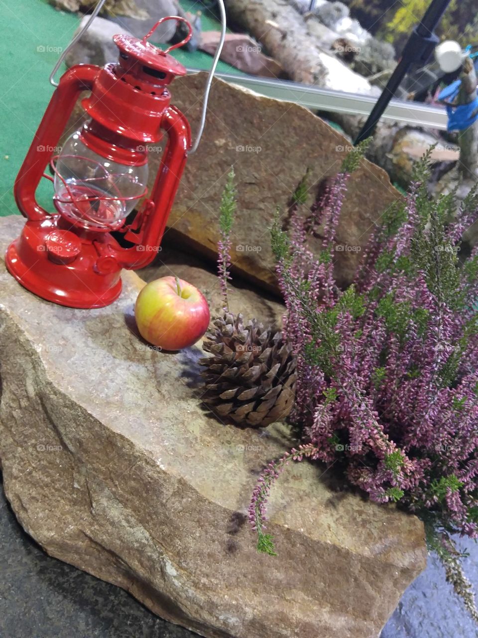 A beautiful still life setup of oil lamp, apple and pine cone. Travel setup.