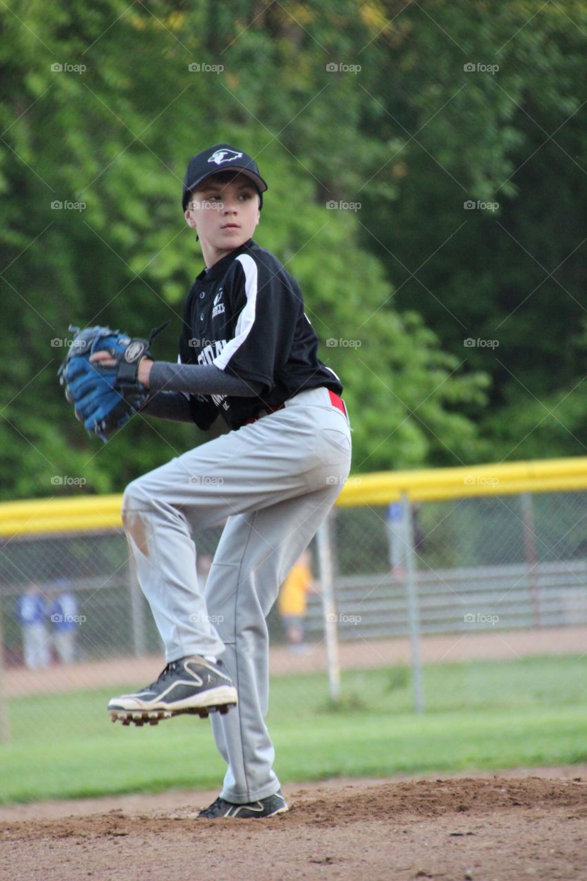 Boy pitching in game