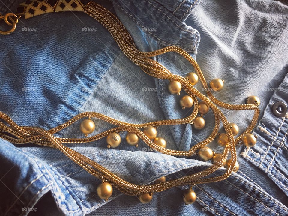 Elevated view of gold necklace on shirt