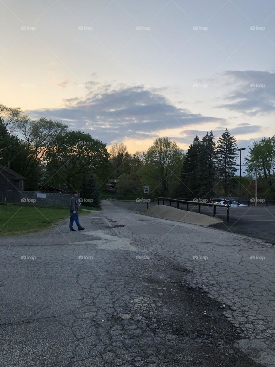 Parking lot scene of a sunset sky and trees and clouds