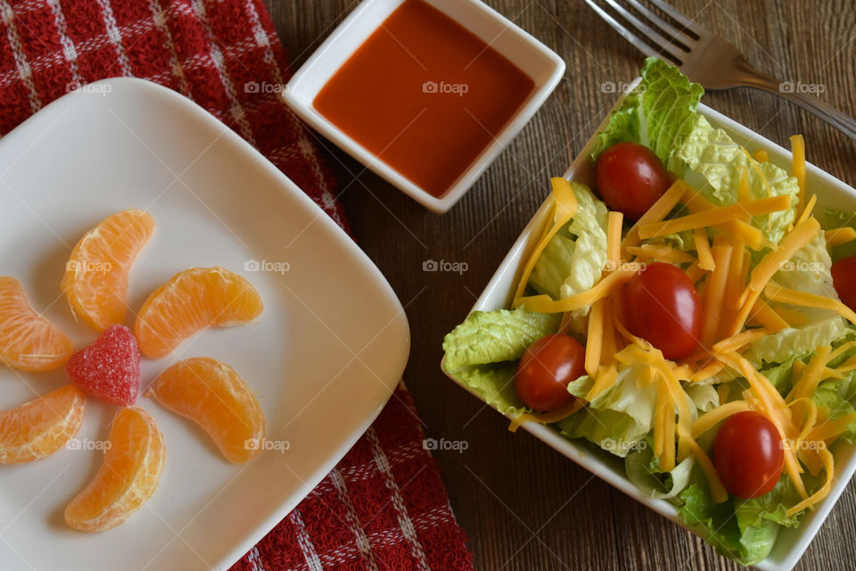 Crisp salad with cheese and a plate of mandarin oranges