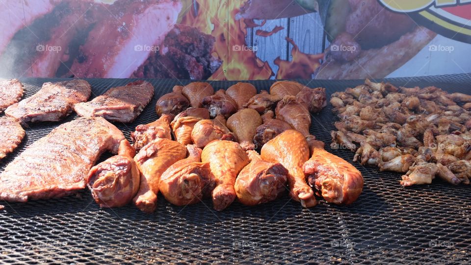 Barbeque, turkey leg, chicken and ribs, sauced and smoking