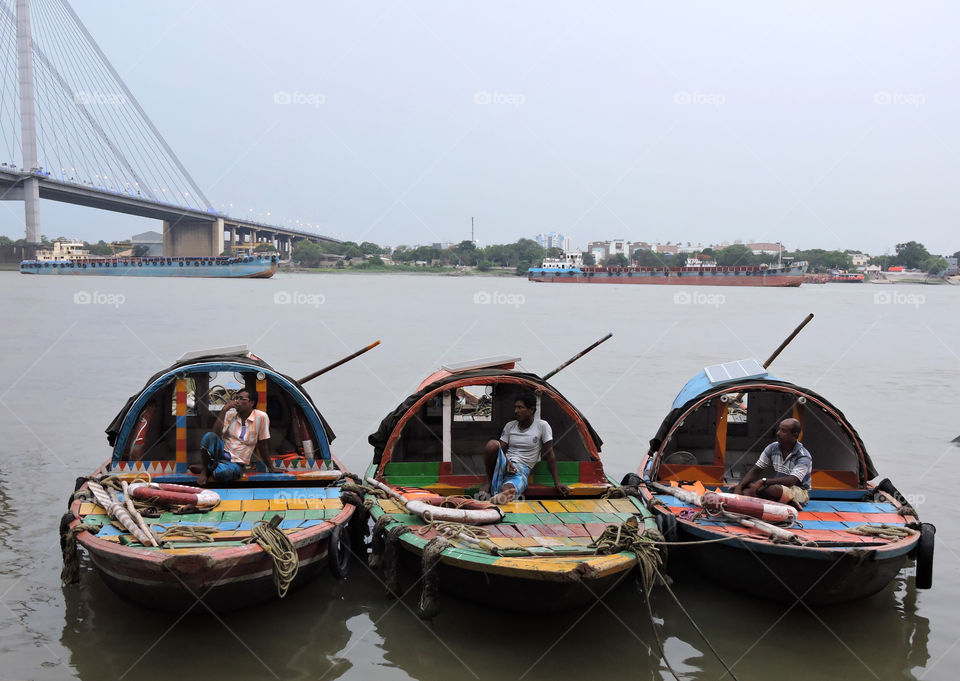 three boats with boatsmen on a river