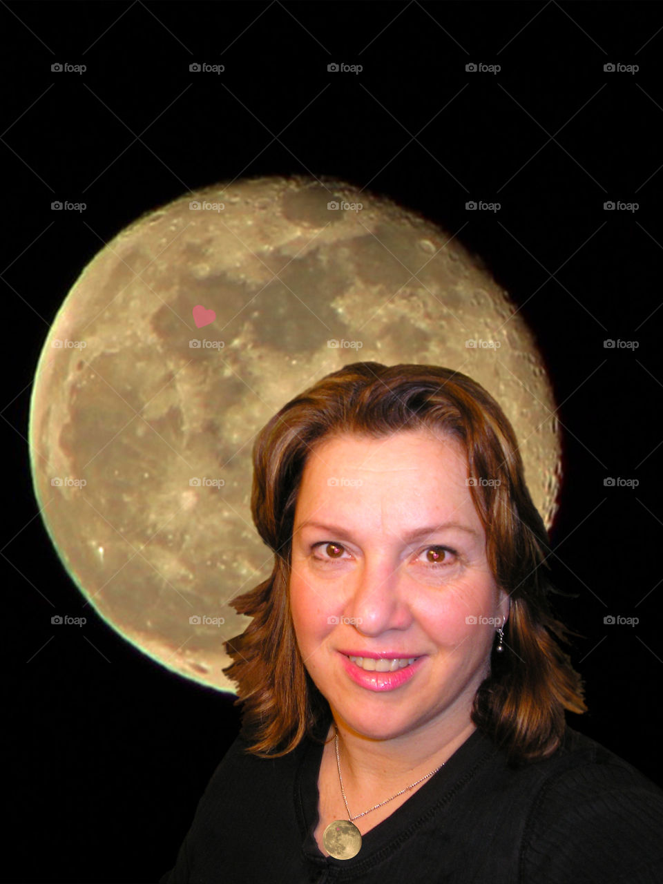 Sea of Serenity:Closeup of a woman in love. Her face is lit as if by the light of the moon. Her expression is calm & the love in her heart is symbolized by the pink hearts in the moon behind her, in the moon of her necklace & in her deep brown eyes.