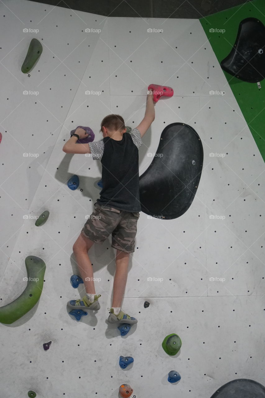 Boy climbing a rock wall
