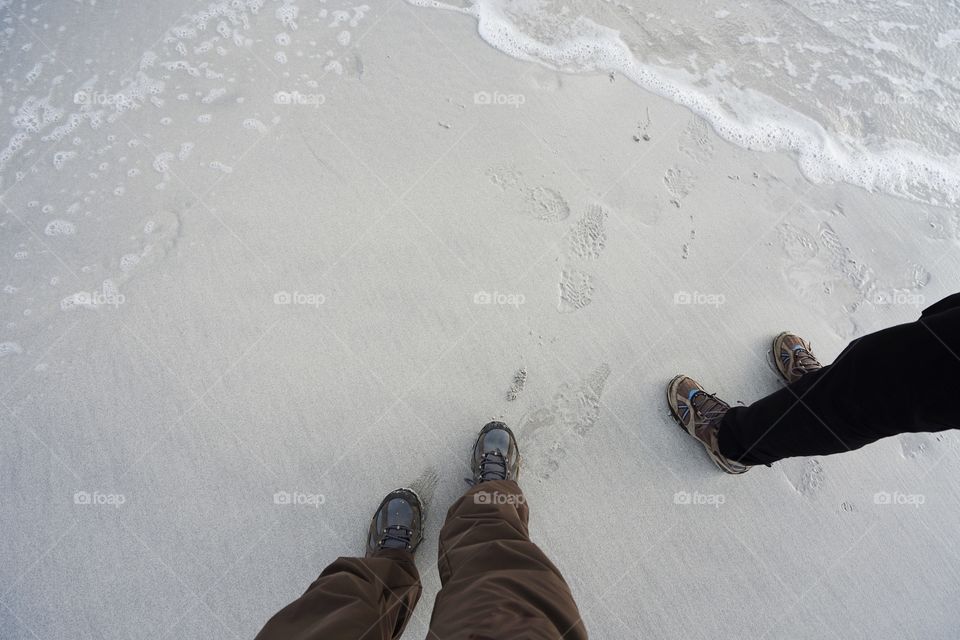 pairs of shoes on the sand couple concept and travel