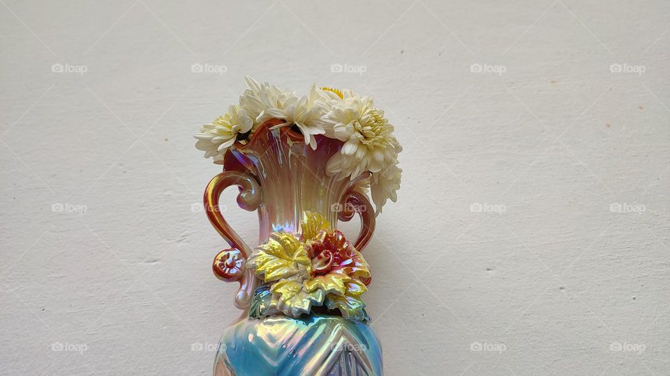 Beautiful white flowers in a colourful flowerpot with a flower sculpture, Flowers in a vase, colourful vase, white flowers in a vase