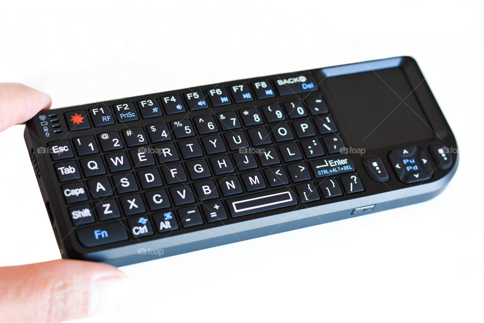 Hand holding mini wireless keyboard isolated on white background