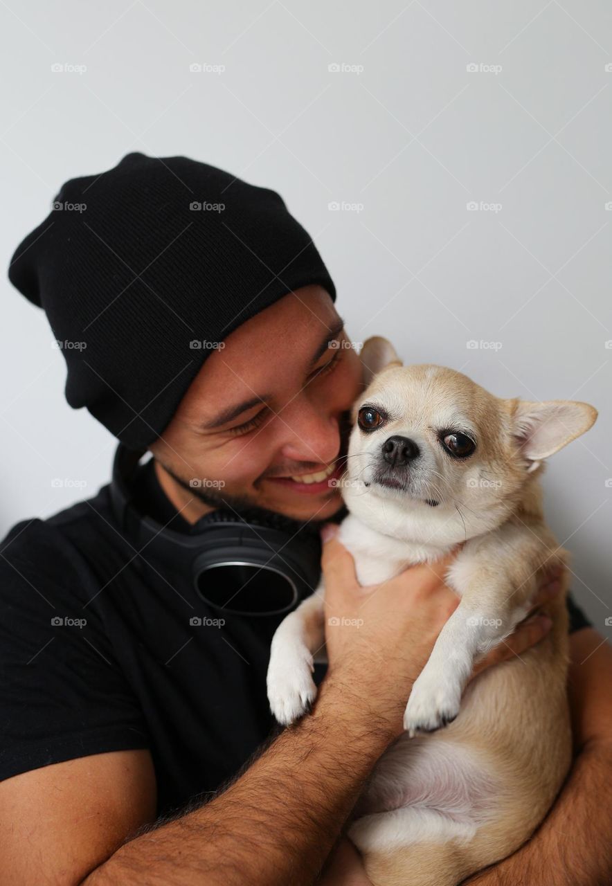 stylish guy in black clothes, with headphones and his best friend, a dog. a twenty-three-year-old teenager, a new generation.