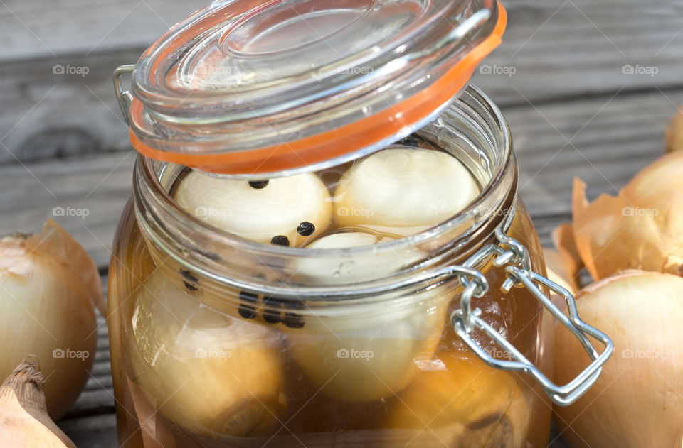 A closeup view of pickled onions inside an open jar.