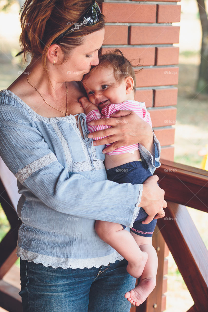 Smiling mother carrying her baby