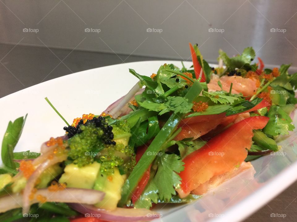 Salad greens with salmon and Tobiko caviar of flying fish.