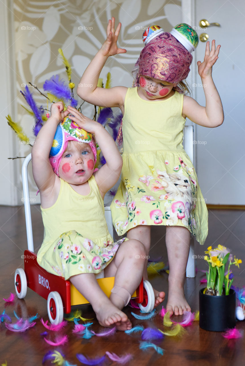Two young sisters having fun infront of the camera with easter theme.