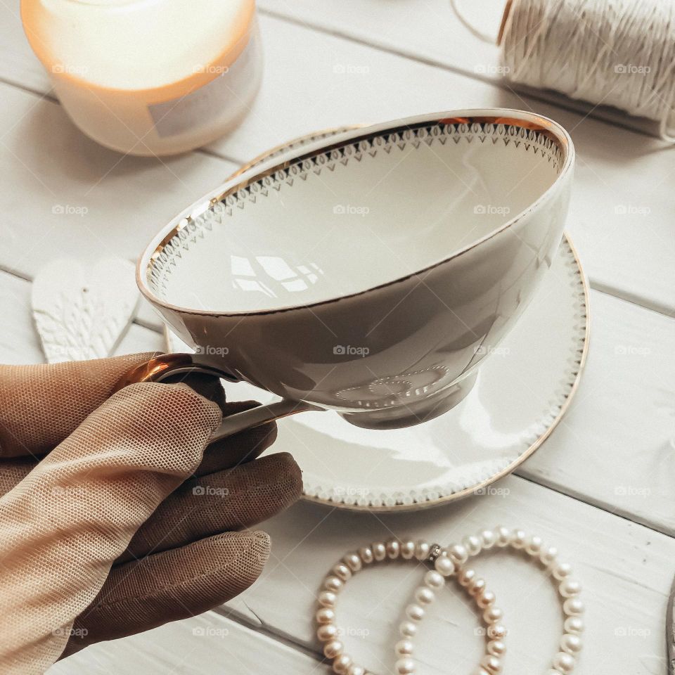 Old porcelain beige cup in hand vintage porcelain cup in hand 