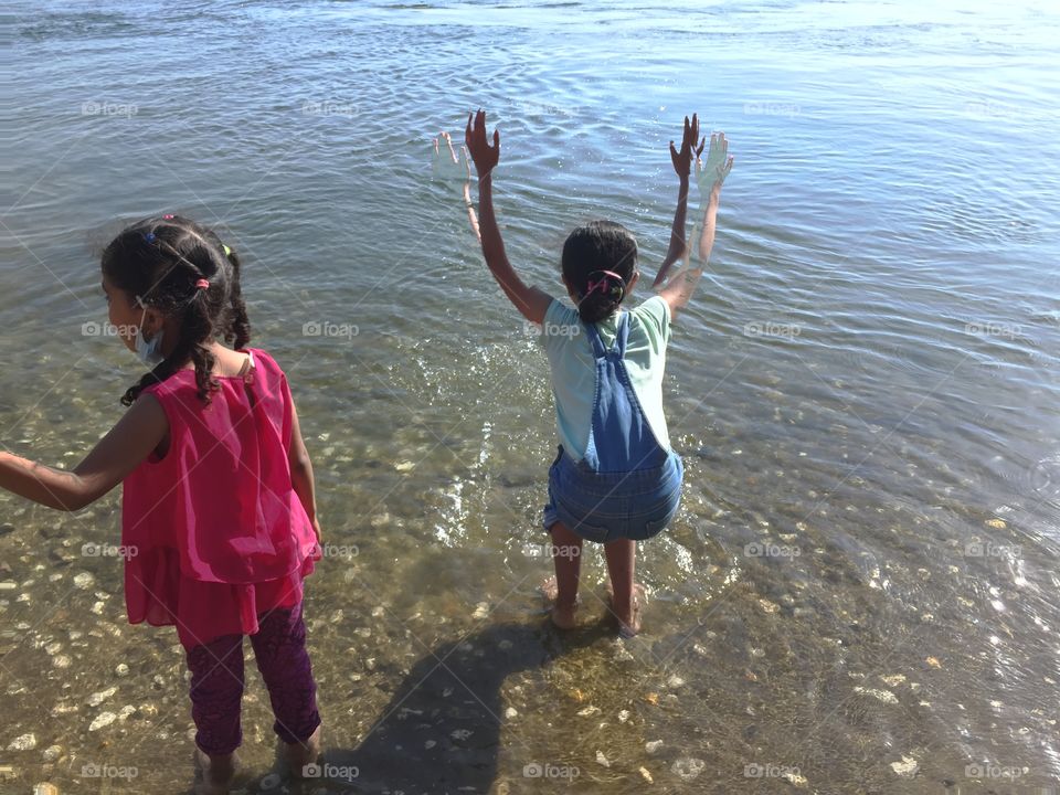 Two little girls have fun by the sea