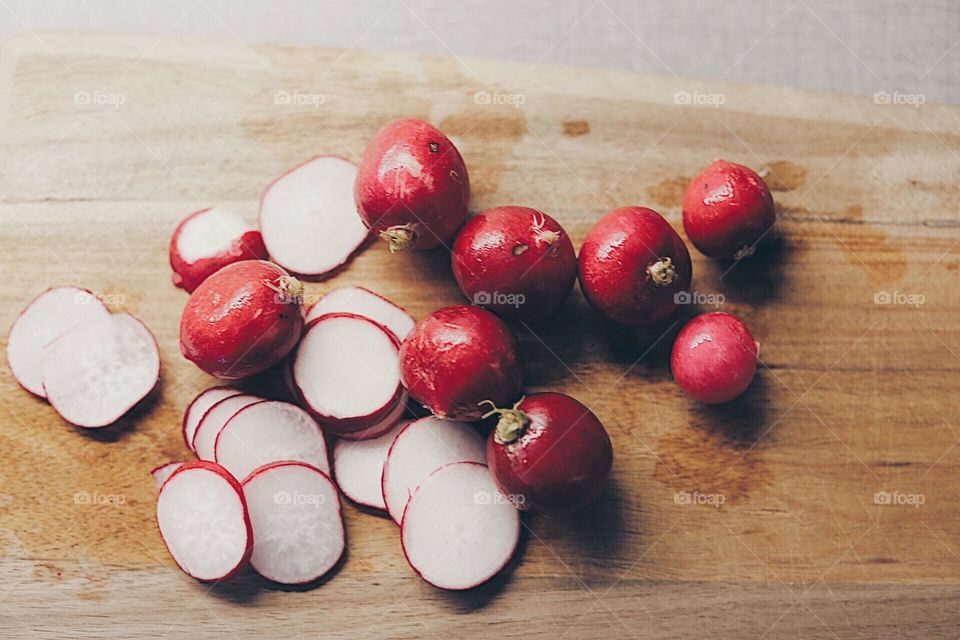 Magenta. Radishes on a wooden cutting board seen from above 