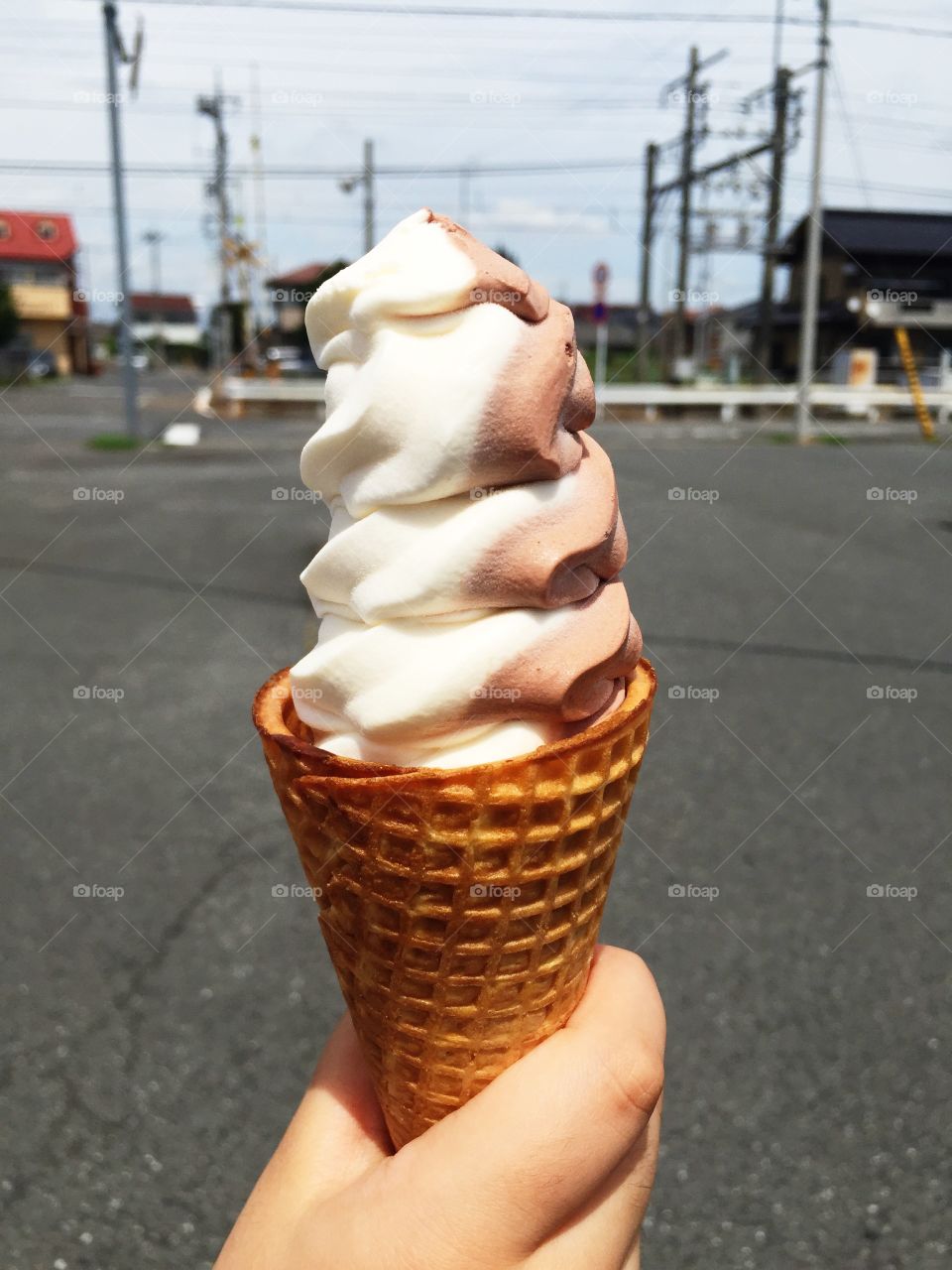 Human hand holding ice cream on street