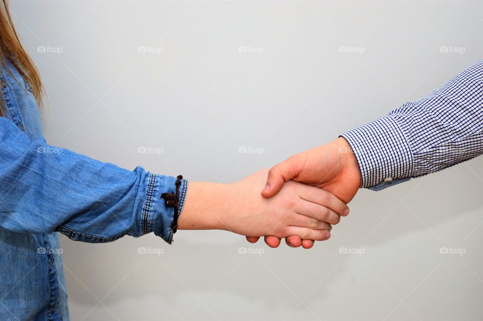 Close-up of holding hands against grey background