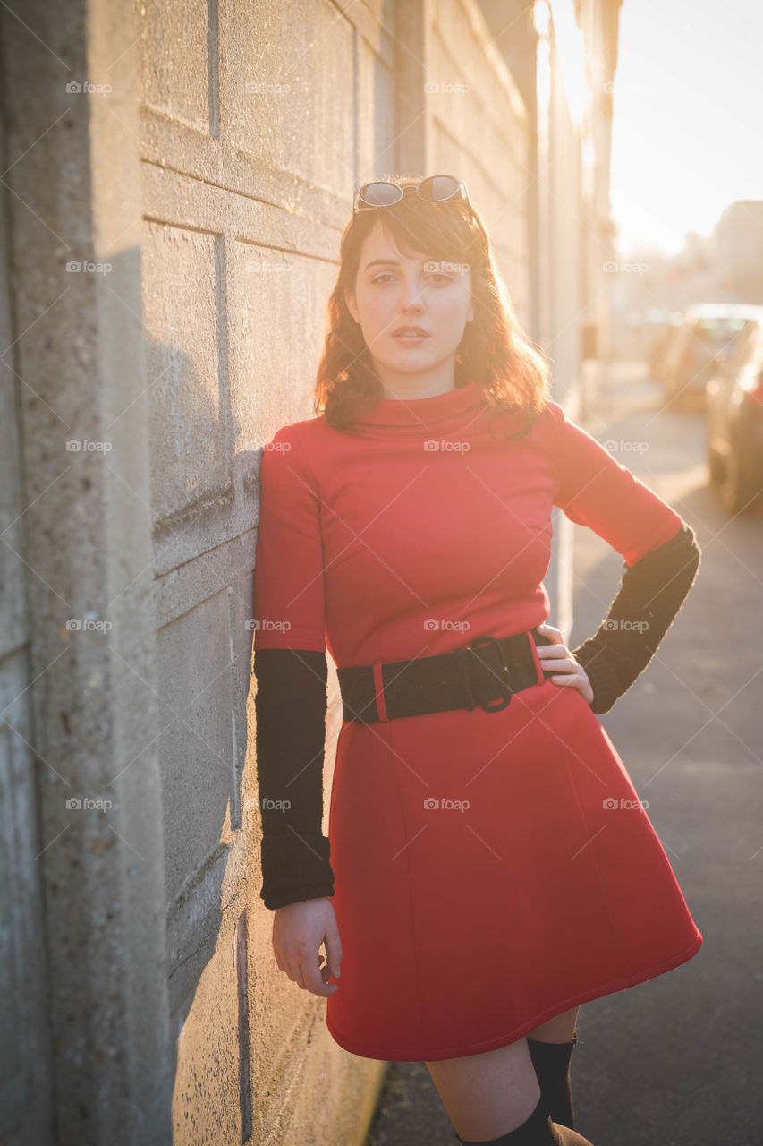 young beautiful girl in the street with red dress