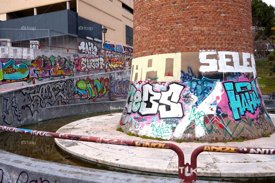 Graffiti around the base of an old smokestack, Jardín del Rastro, Madrid 